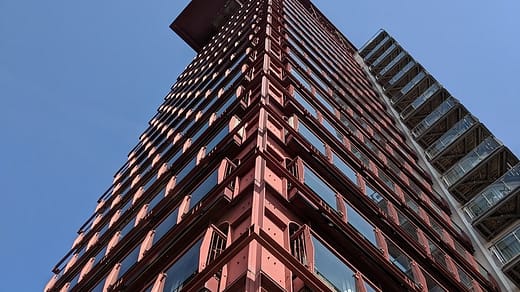 steel building low angle photography of pink high-rise building