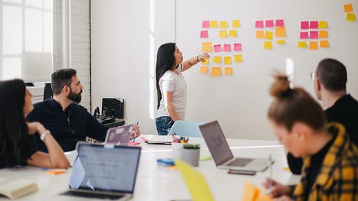 Leadership Development Program woman placing sticky notes on wall