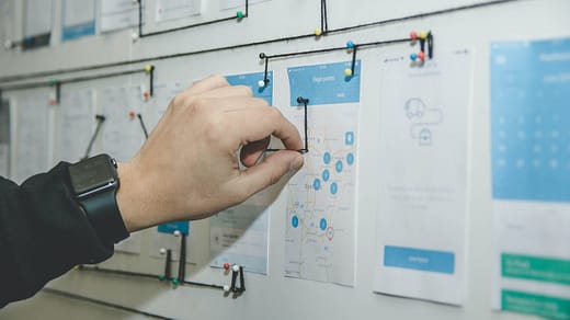 person working on blue and white paper on board