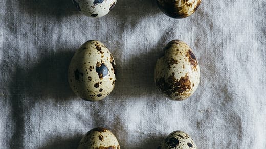 six quail eggs on grey cloth