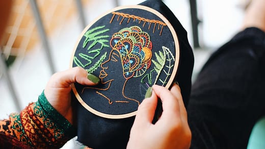 embroidery business - person holding blue and white round ornament