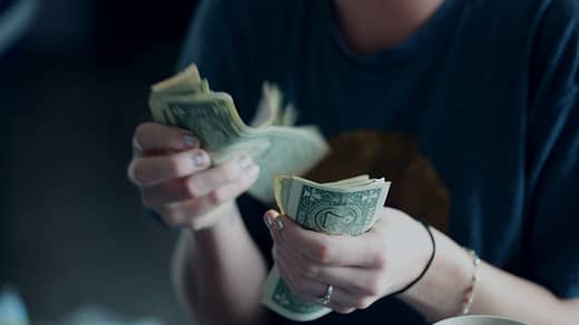 Personal Finance focus photography of person counting dollar banknotes