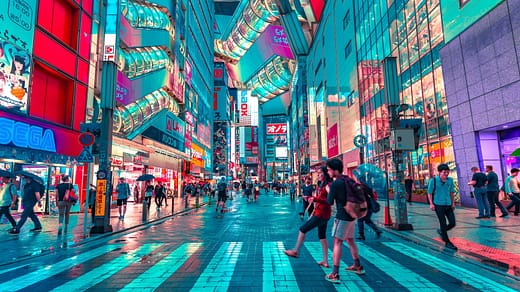 people walking on road near well-lit buildings