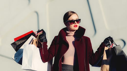 photo of woman holding white and black paper bags