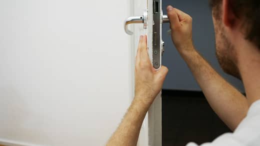 person holds door lever