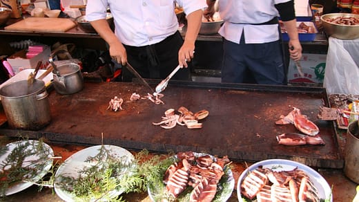 man slicing squids