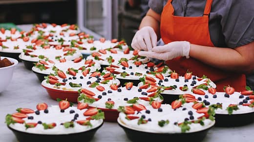 person decorating dishes on table