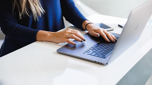 woman in blue long sleeve shirt using macbook pro