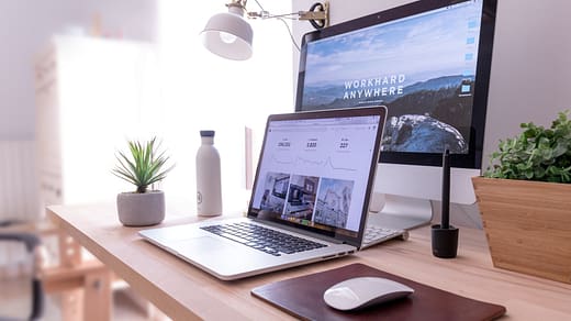 MacBook Pro on table beside white iMac and Magic Mouse