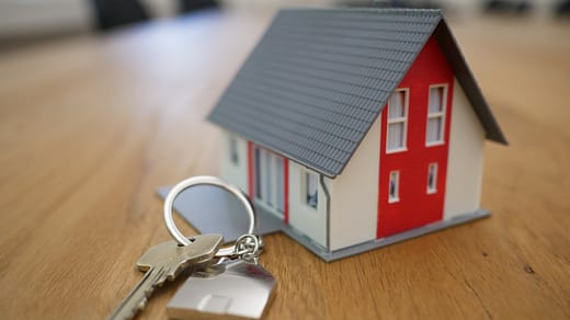 white and red wooden house miniature on brown table