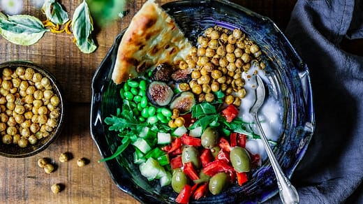 silver spoon on black ceramic bowl with vegetables