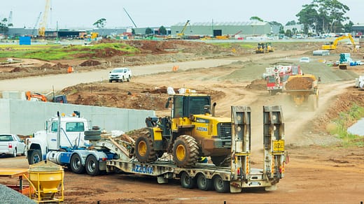 yellow and black heavy equipment on brown field during daytime