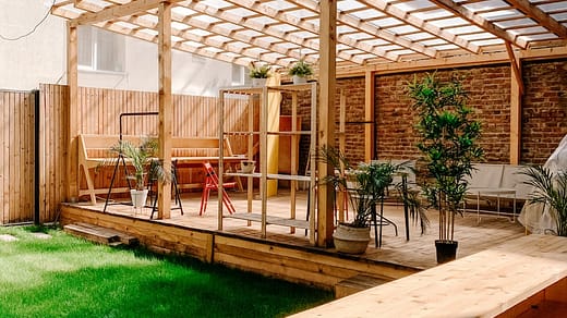 brown wooden fence near green plants during daytime