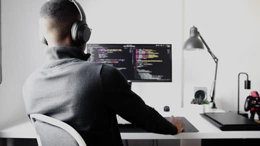 man in black long sleeve shirt wearing black headphones sitting on chair