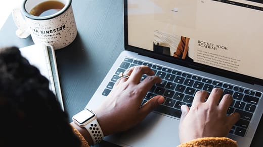 person using macbook pro on black table