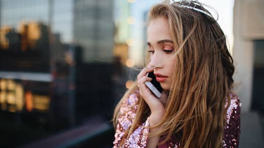 shallow focus photography of woman using smartphone outdoors