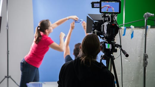 woman in pink long sleeve shirt holding black video camera