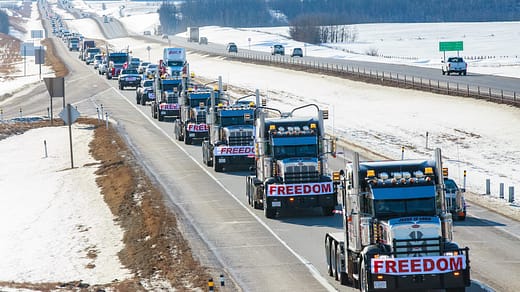 a long line of trucks driving down a highway