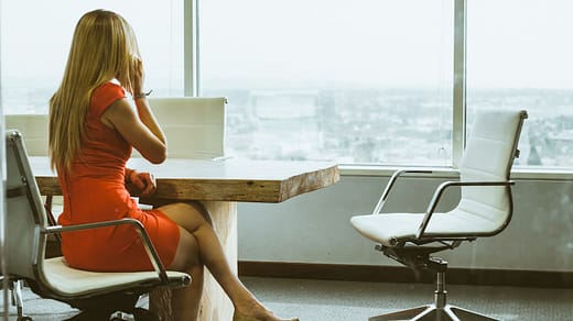 woman talking through mobile phone while sitting on swivel armchair