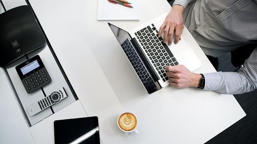 person using laptop on white wooden table