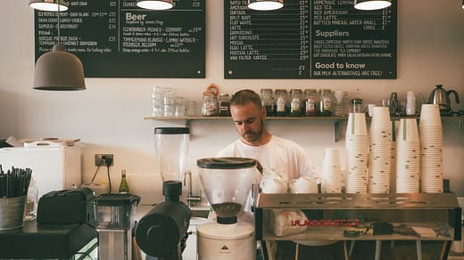 man in white dress shirt standing in front of kitchen counter