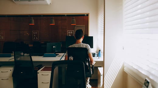 Person in Gray Shirt Sitting on Computer Chair