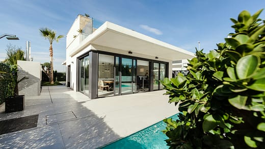 white and grey concrete building near swimming pool under clear sky during daytime