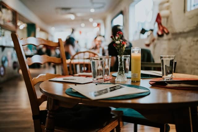 Close-up of a small wooden table and chairs in a restaurant